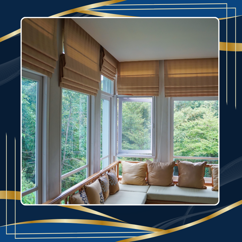 ผ้าม่านพับ (Roman Blinds) สีเบจ ติดตั้งบริเวณหน้าต่างบานใหญ่ มองเห็นวิวธรรมชาติ